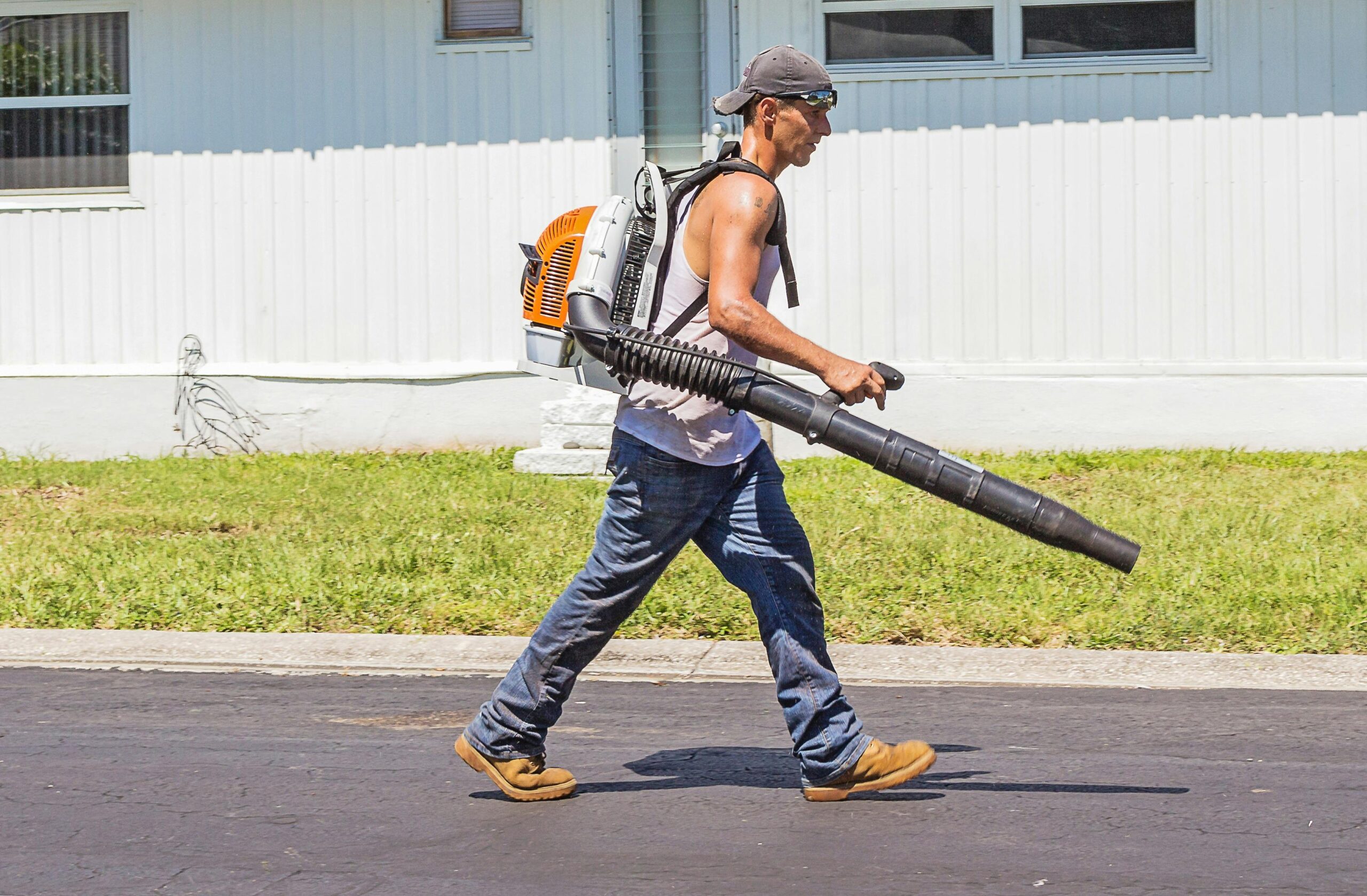 Landscaper wearing backpack blower and working for staffing and temp agency.